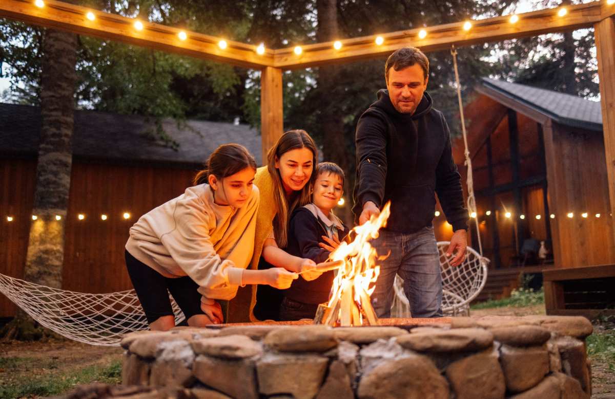 family cooking food on firepit
